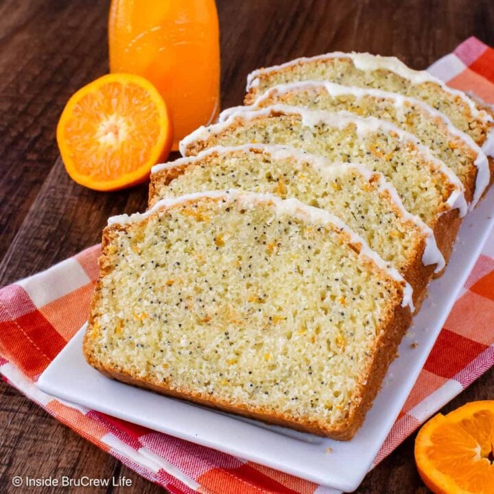 Slices of orange bread with frosting on a white plate.