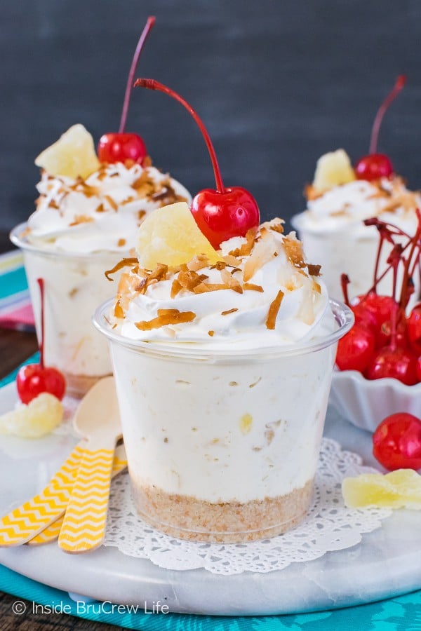 No Bake Pina Colada Cheesecake Parfaits - these cute little no bake cups are full of coconut and pineapple goodness. Easy recipe to make for summer picnics or parties!
