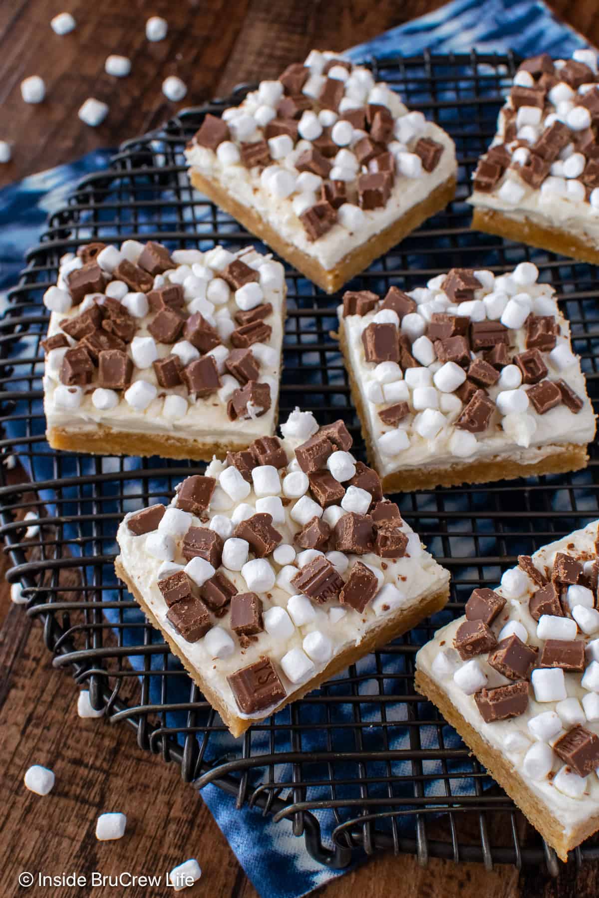 A black wire rack with frosted s'mores cookie bars on it.