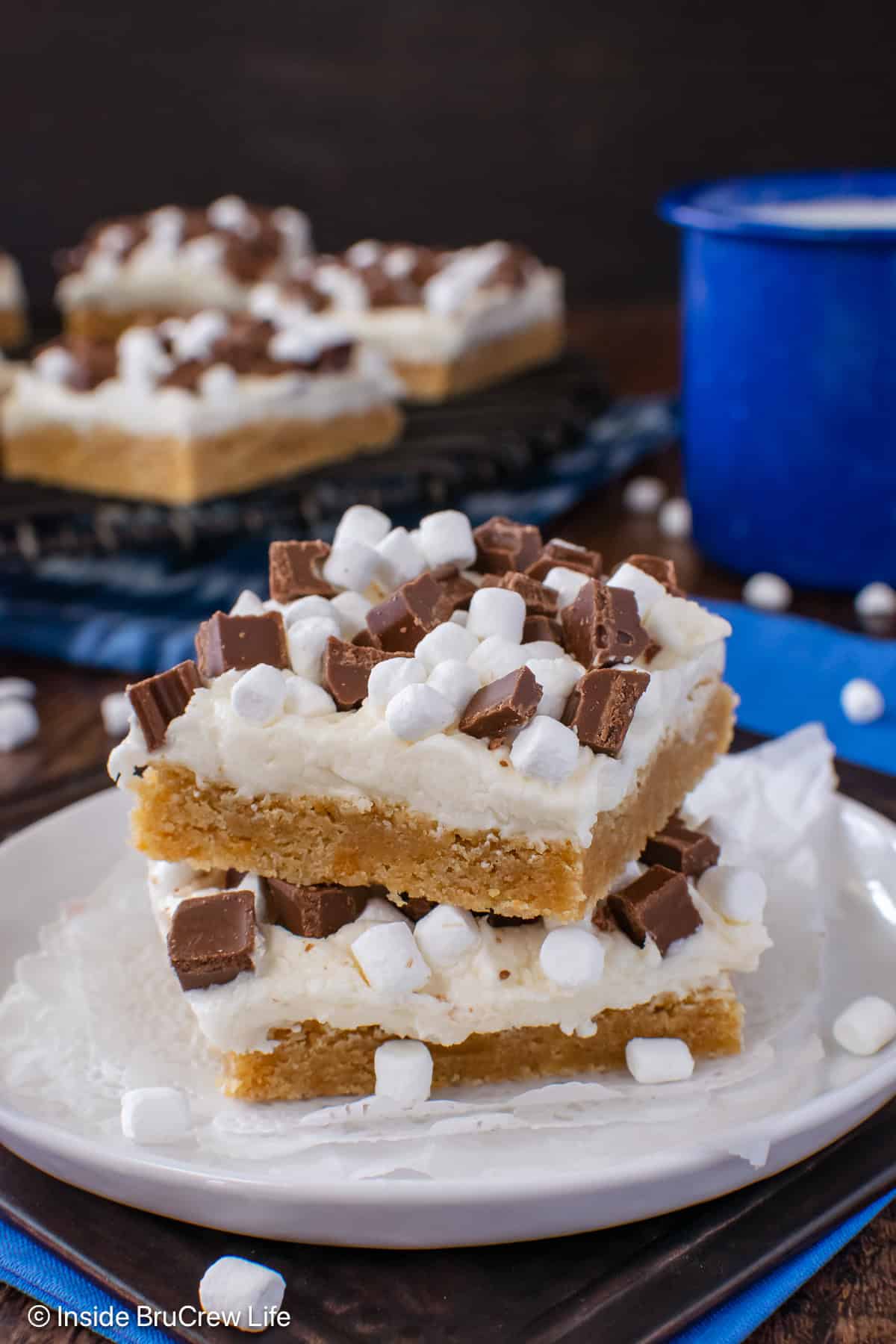 Two s'mores cookie bars stacked on a white plate.