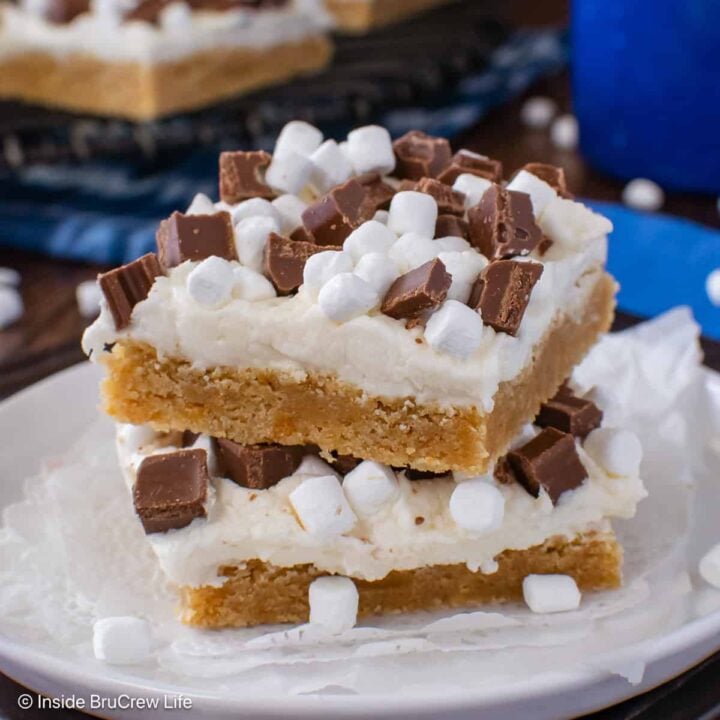Two s'mores cookie bars stacked on a white plate.