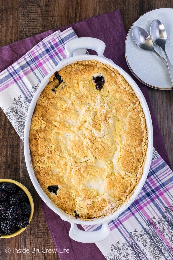 Overhead picture of a white casserole dish filled with a baked blackberry dump cake with a lemon cake mix.