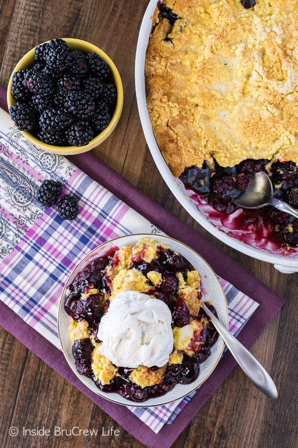 Overhead picture of a plate with blackberry lemon dump cake on it and the dish of dump cake beside it