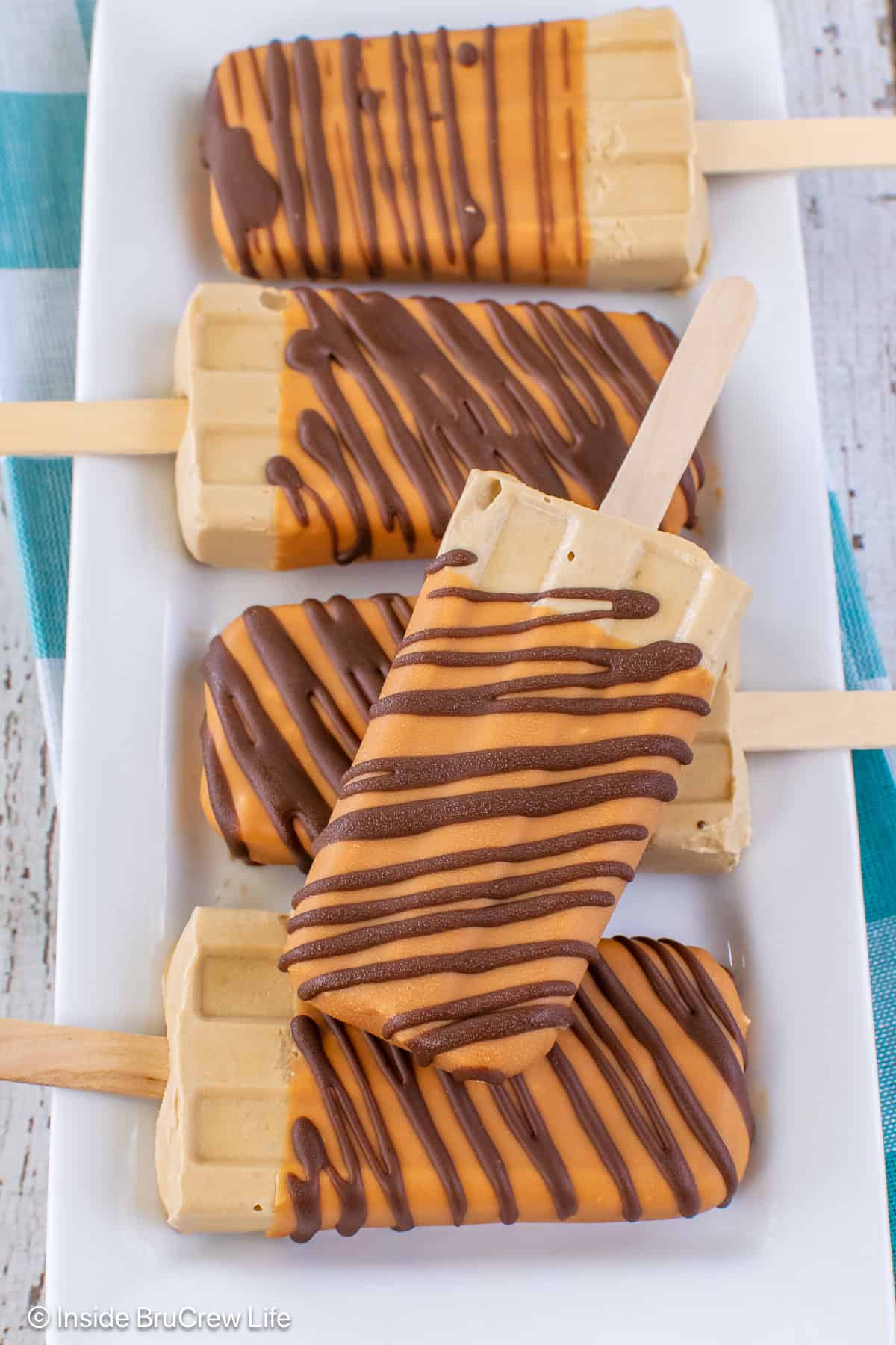 Five caramel coffee pudding pops on a white plate.