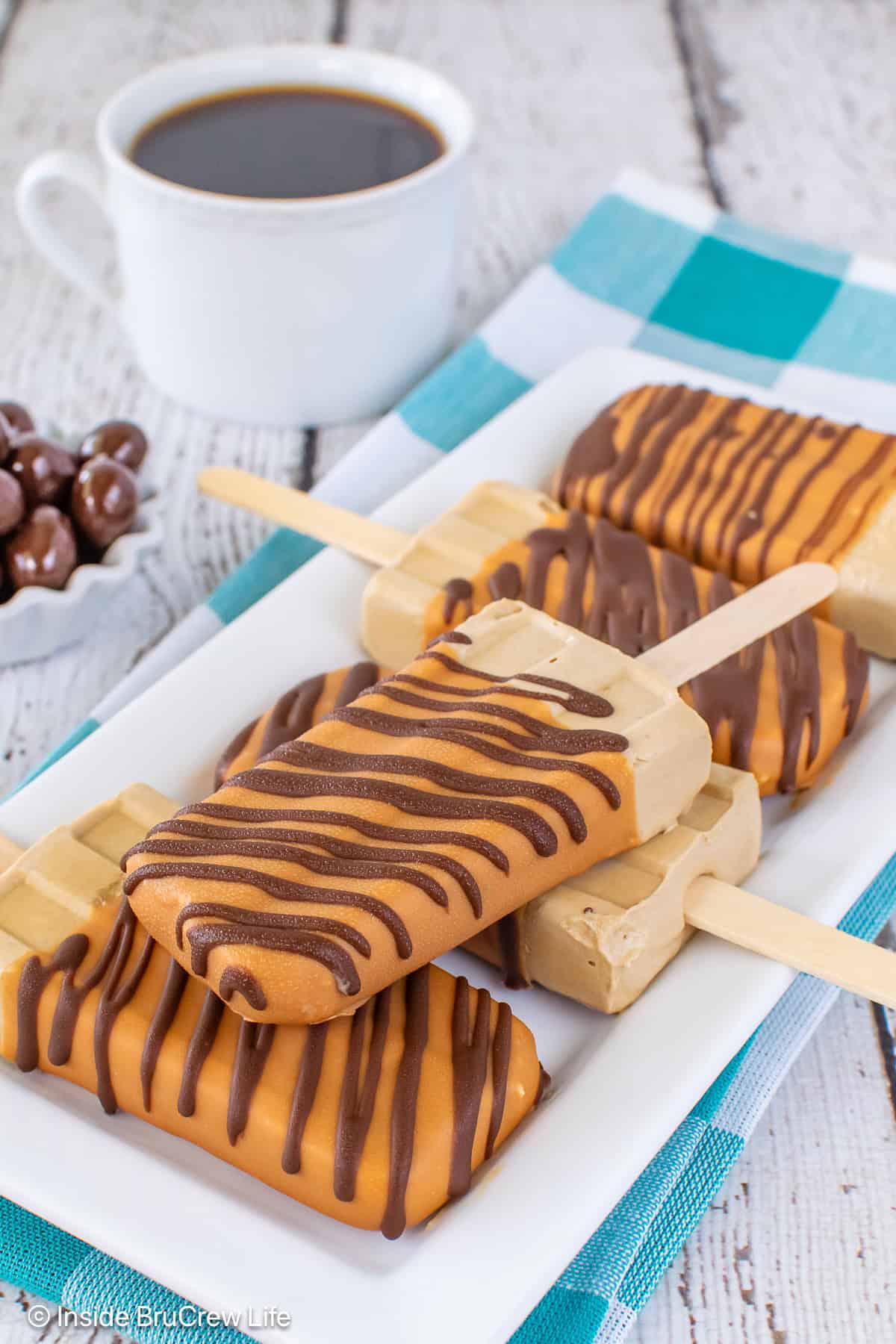 Five caramel coffee pudding pops on a white plate.
