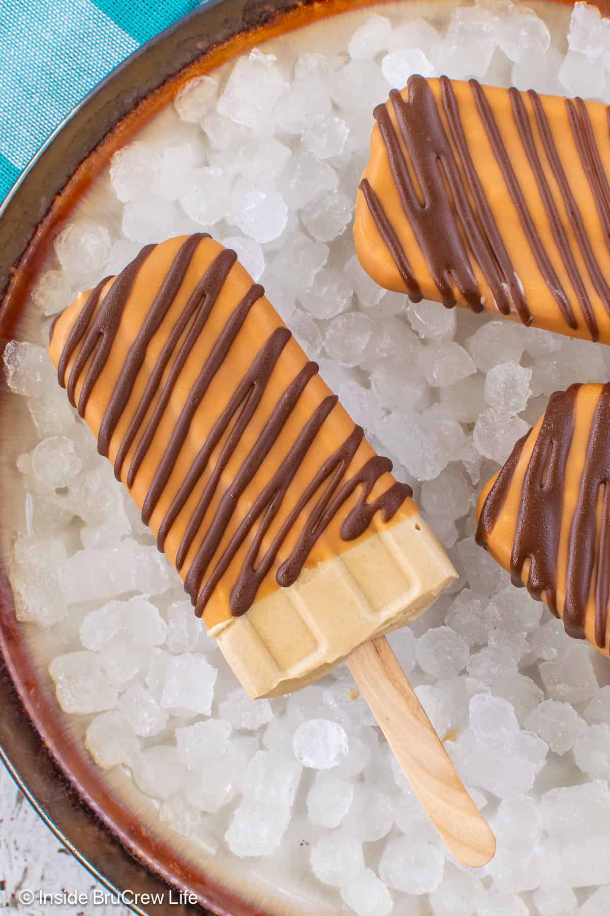 A plate of ice with coffee popsicles on it.