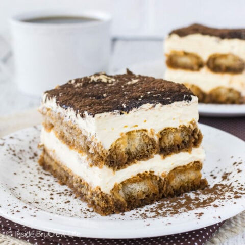 A white plate with a slice of easy tiramisu with cocoa powder on top in it