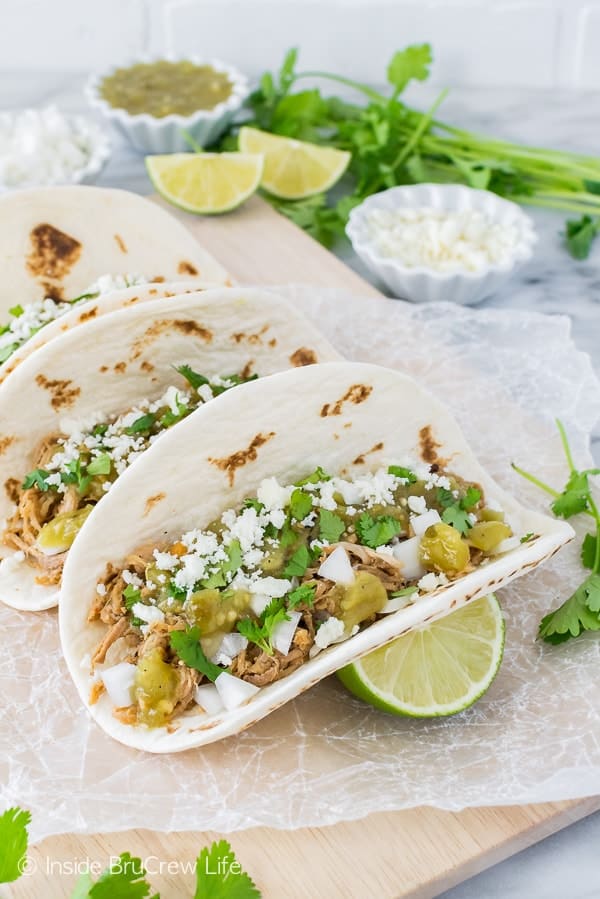 Green Chile Pulled Pork Tacos - these easy tacos are loaded with meat, cheese, and veggies. Great dinner recipe for busy nights!