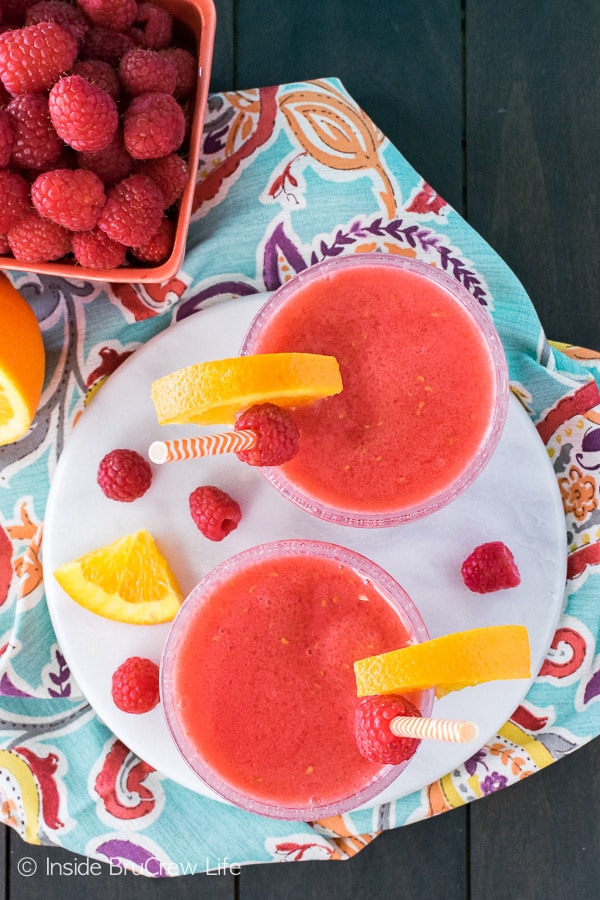 Raspberry Orange Slushies - this easy blended drink is perfect for cooling off on a hot summer day! Fresh fruit, juice, and ice is all you need for this easy recipe!