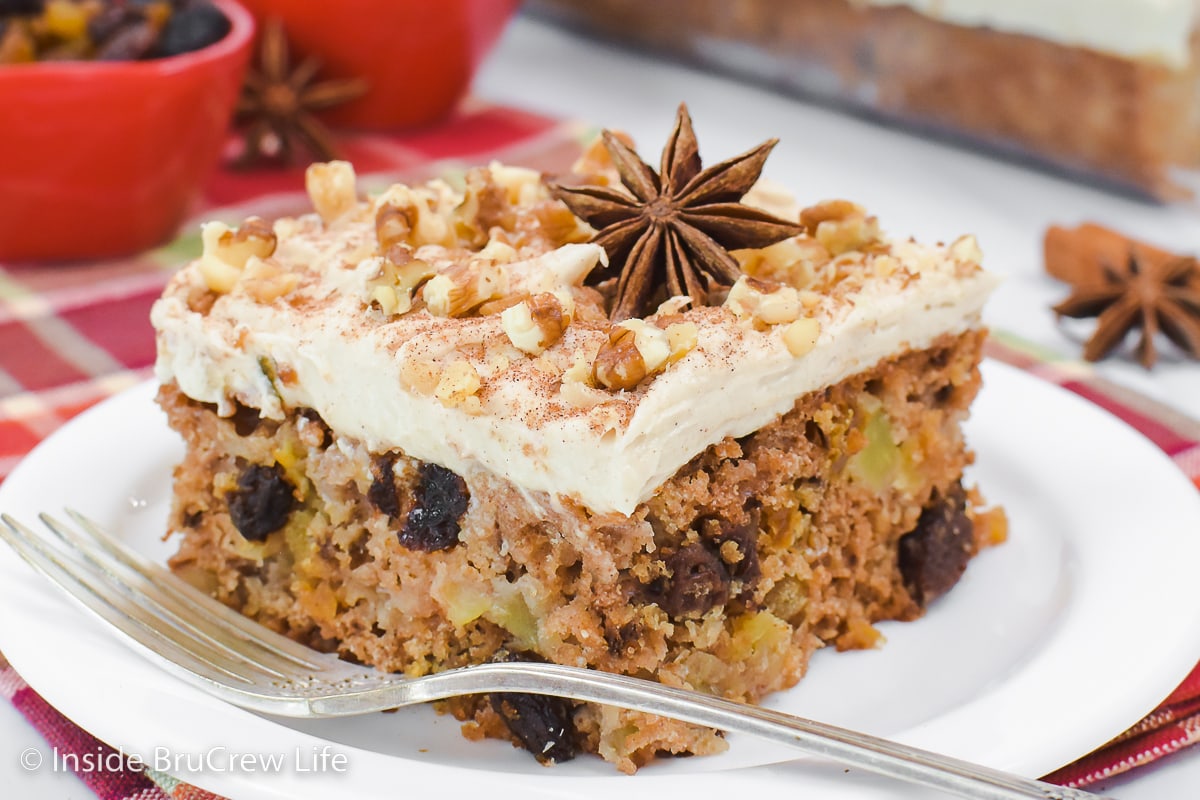 A slice of frosted apple cake on a plate.