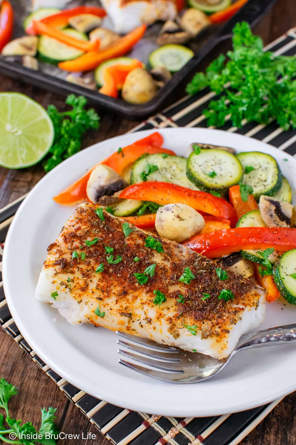 Chili lime cod and roasted veggies on a white plate.