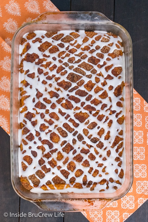 Overhead picture of a pan of churro pumpkin pie cheesecake danish drizzled with a sweet glaze