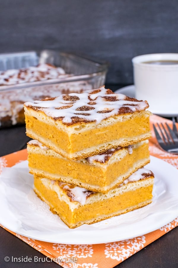 Three squares of churro pumpkin pie cheesecake danish on a white plate