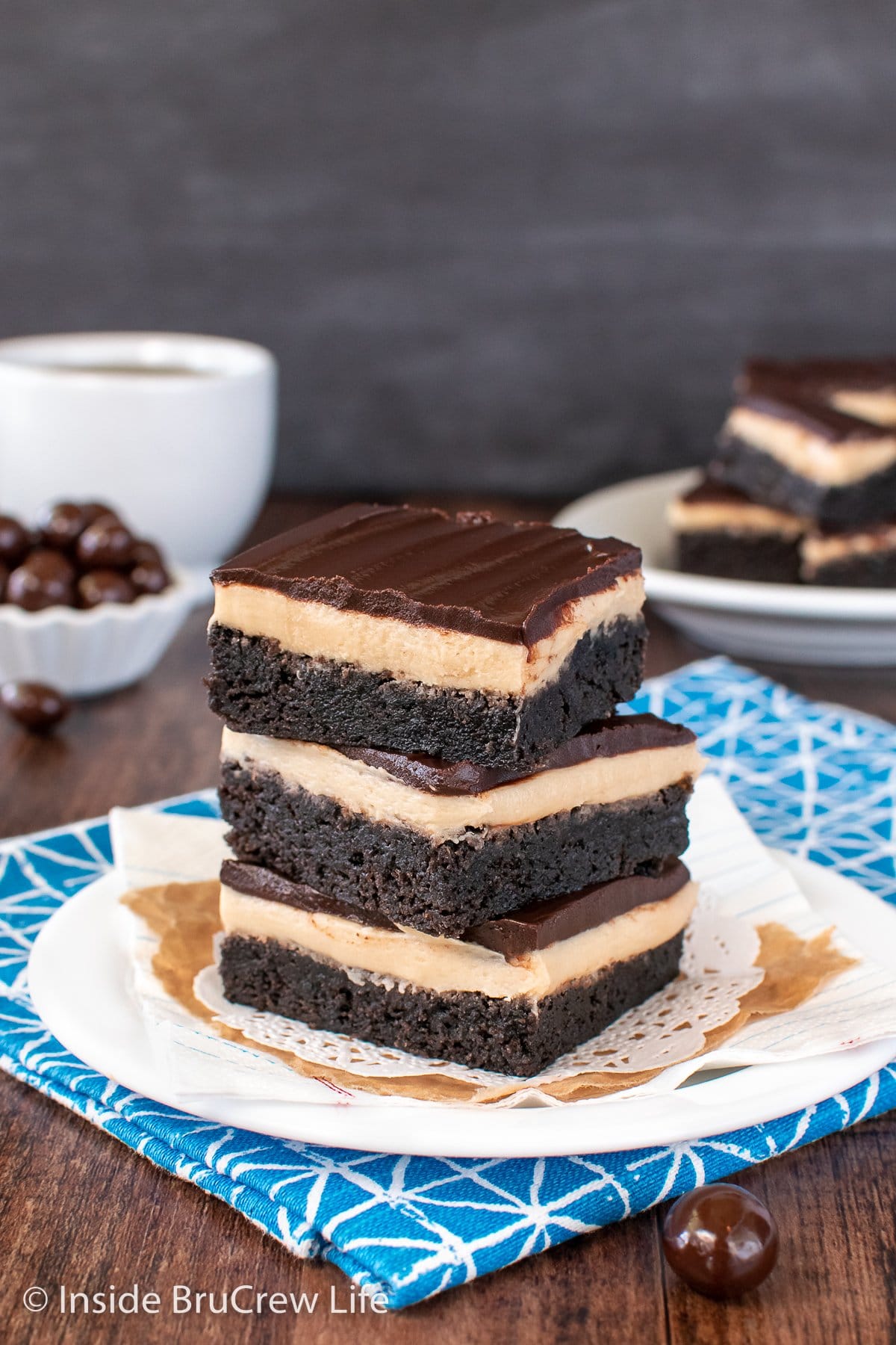 Three brownies stacked on a plate.