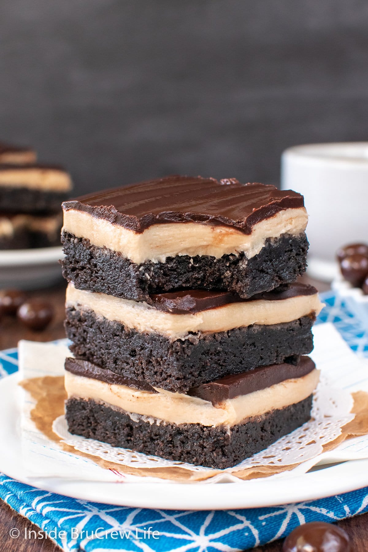 Three brownies stacked on a plate.