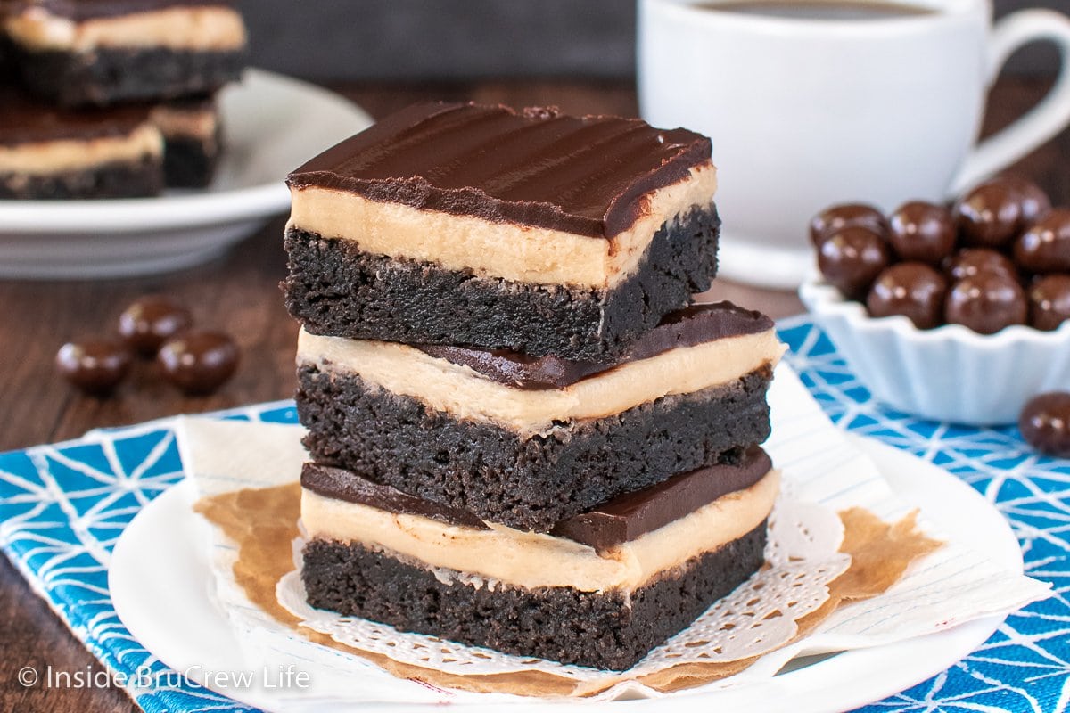 A white plate with three brownies on it.