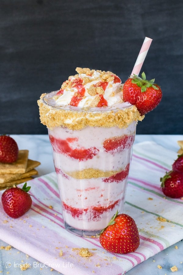 Strawberry Cheesecake Milkshakes - layers of cookie crumbs, strawberry sauce, and a sweet strawberry milkshake makes a fun frozen drink. Easy recipe for a hot summer day!