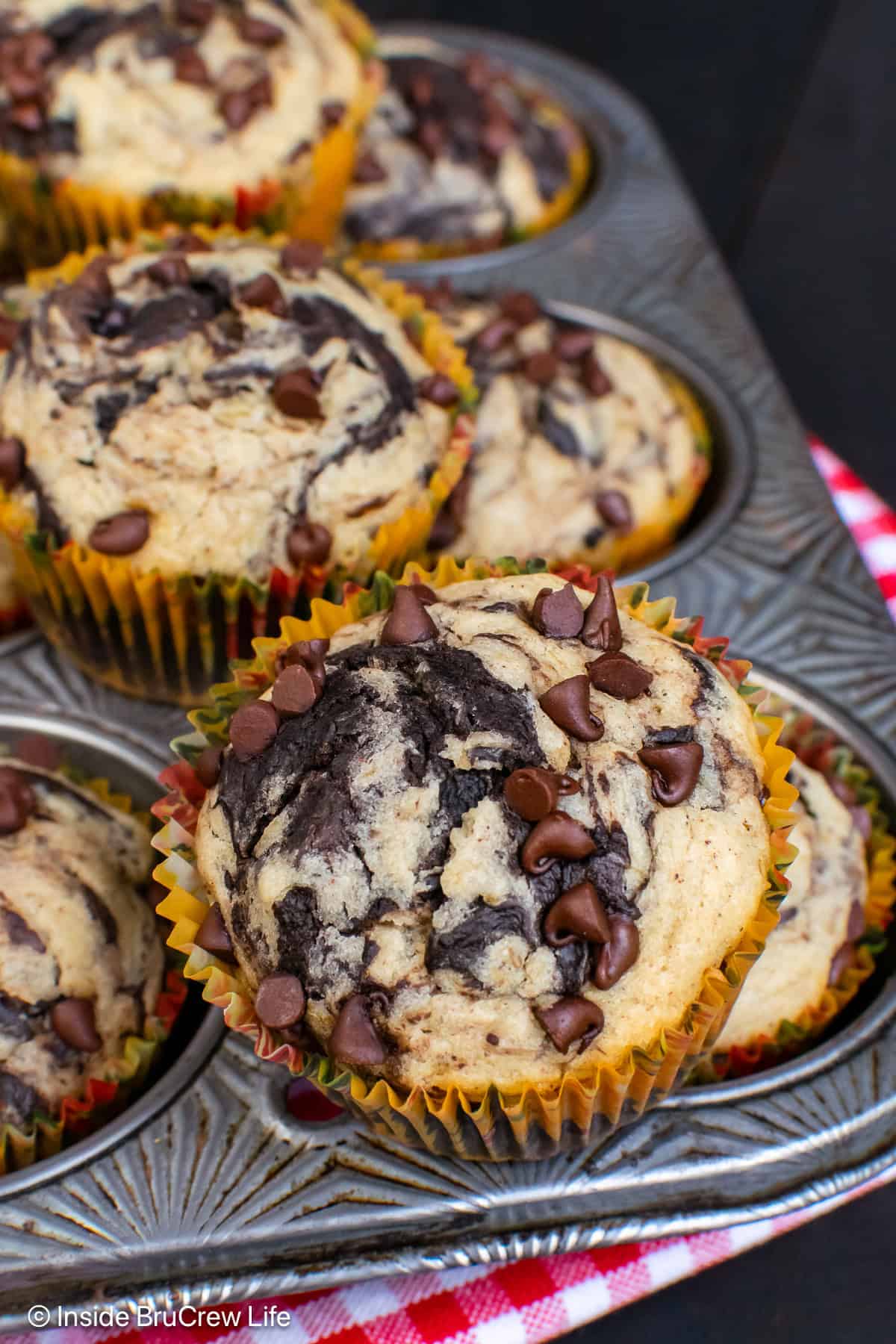 Chocolate banana marble muffins in a metal muffin tin.