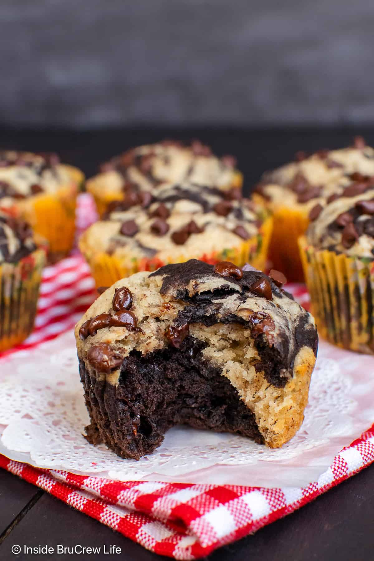 A banana marble muffin with a bite taken out so you can see the swirls inside.