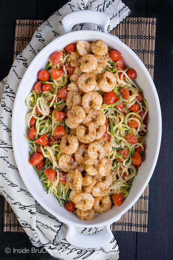 An overhead pictures of a white casserole dish filled with parmesan garlic shrimp zucchini noodles