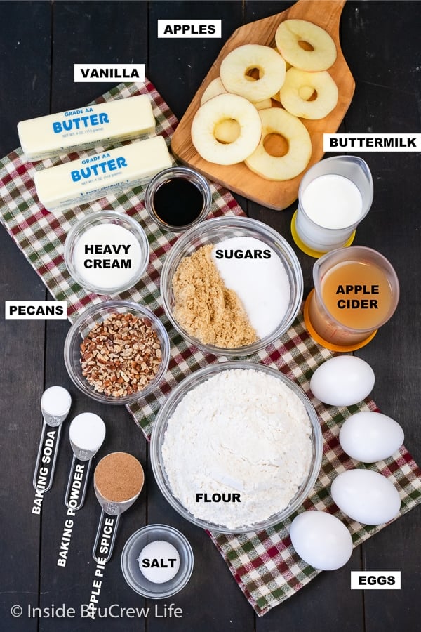 A brown board with bowls of ingredients needed to make an apple upside down cake.