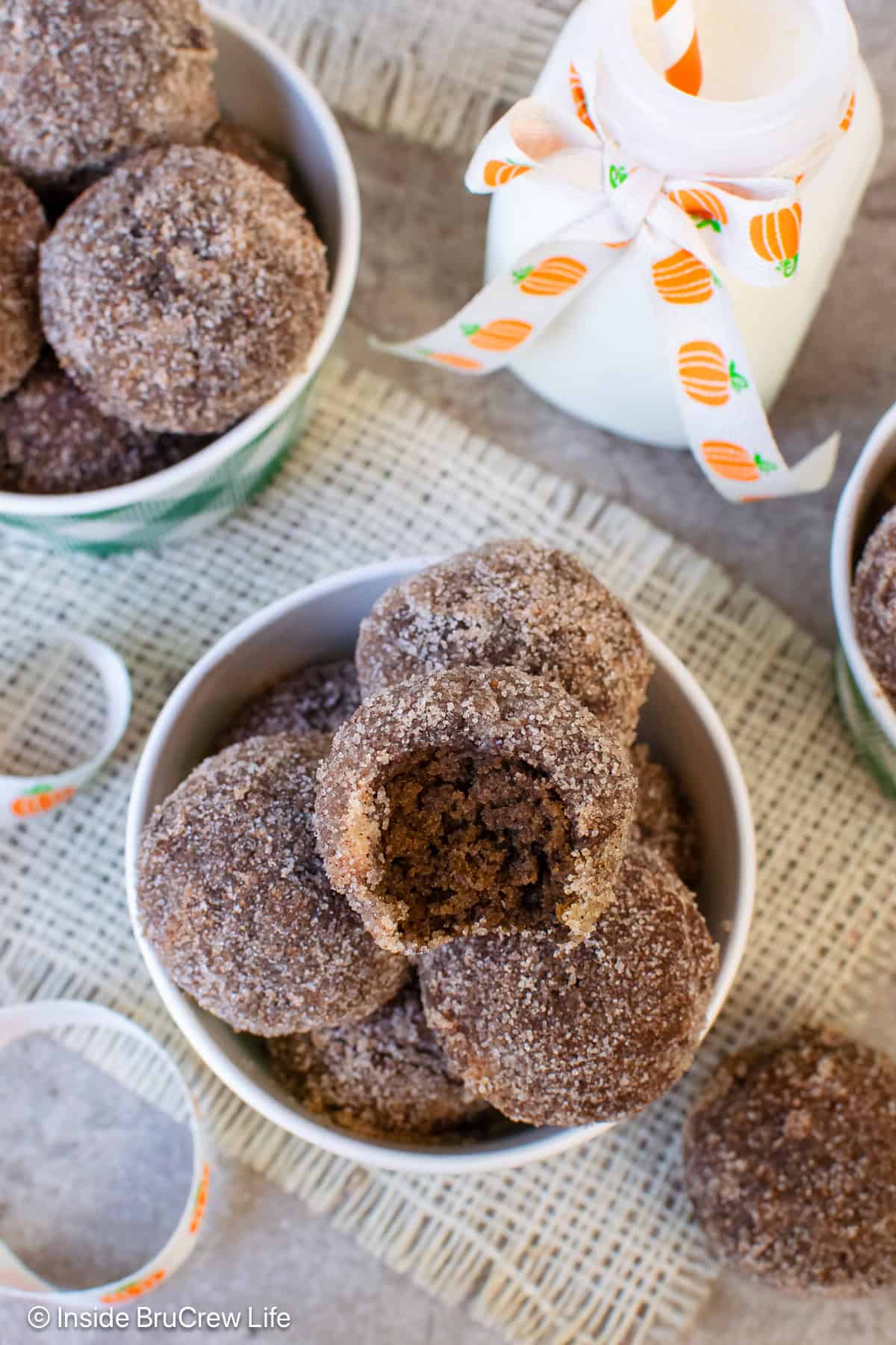 Sugar coated chocolate pumpkin donut holes in a container.
