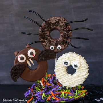 Three chocolate dipped apple slices decorated like Halloween monsters.