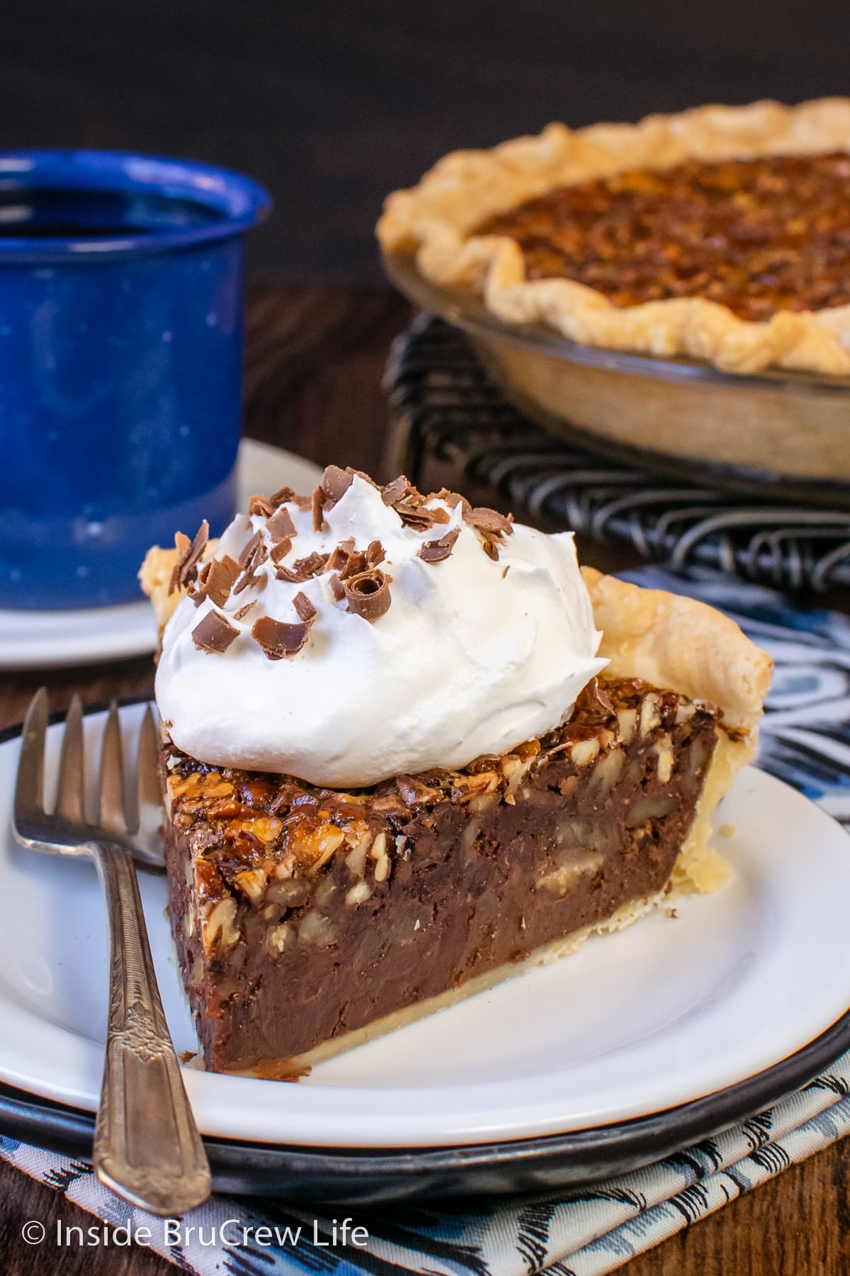 A slice of chocolate pie with whipped cream on a white plate.