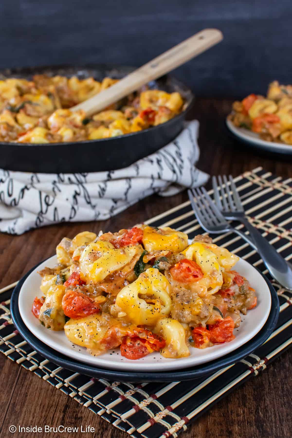 A white plate with a serving of bacon cheeseburger tortellini on it.