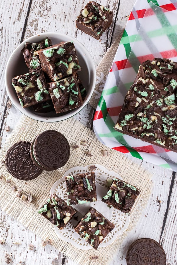 Multiple pieces of chocolate fudge loaded with green mint cookies and mint chips.