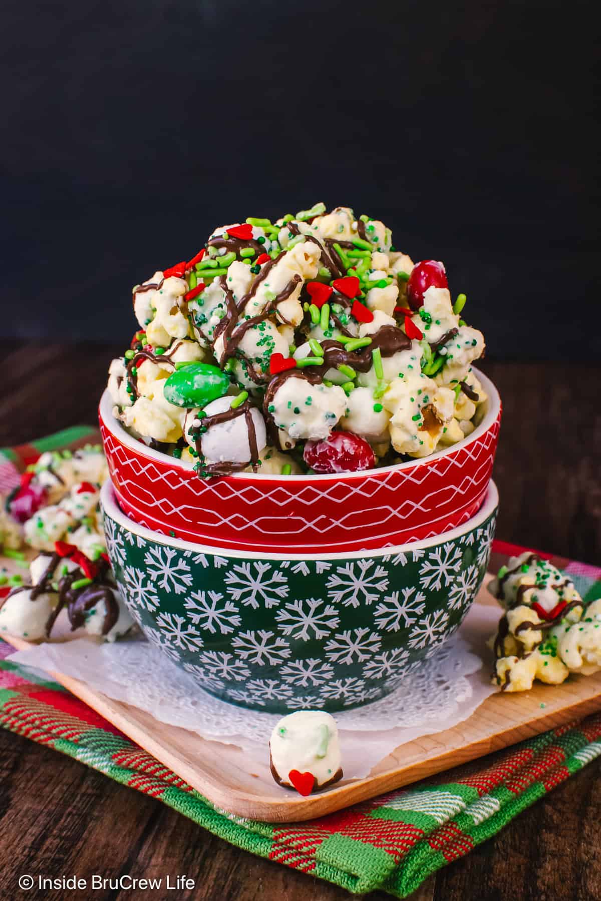 Two stacked bowls filled with chocolate covered Grinch popcorn in it.