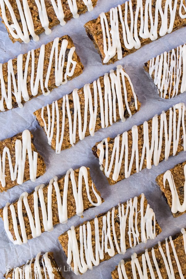 A white background with gingerbread oatmeal bars with white chocolate drizzles on it