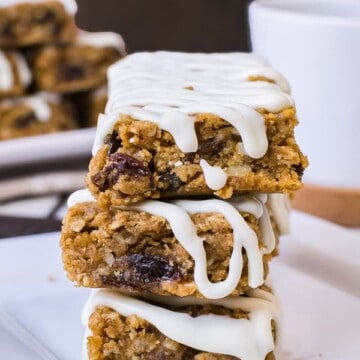 Three iced gingerbread oatmeal bars stacked on a white plate