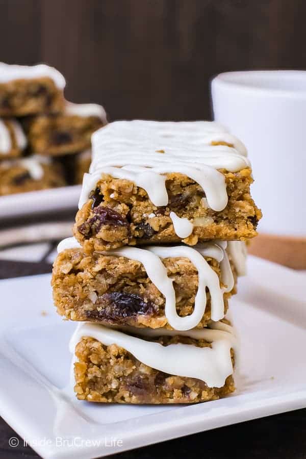 A white plate with three gingerbread oatmeal bars drizzled with white chocolate on it