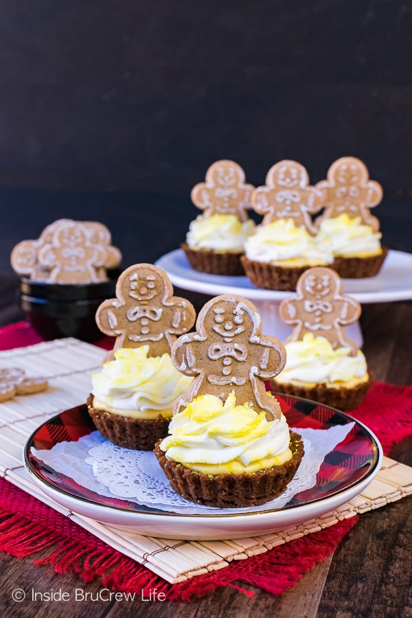 Ginger men sitting on top of Lemon Gingersnap Cheesecake Tarts.