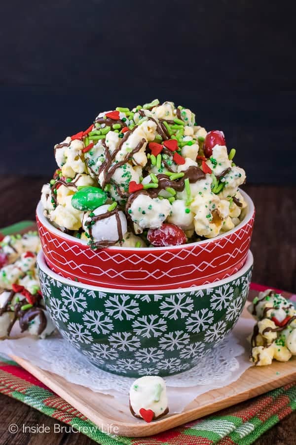 Christmas bowls filled with Mint Grinch Popcorn.
