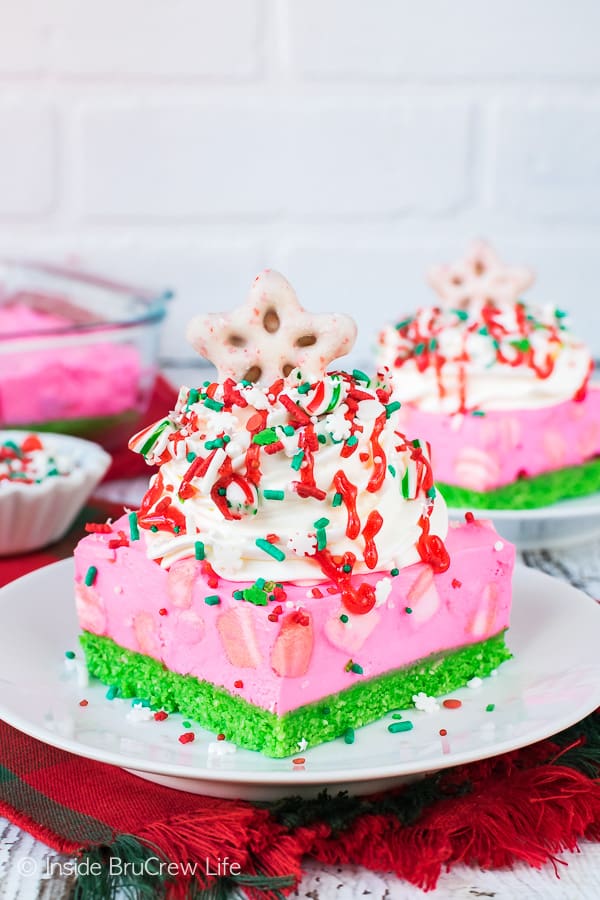 No Bake Peppermint Cheesecake Bars on a white plate with a white brick background.