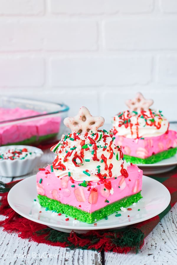 No Bake Peppermint Cheesecake Bars loaded with cool whip and red and green sprinkles.