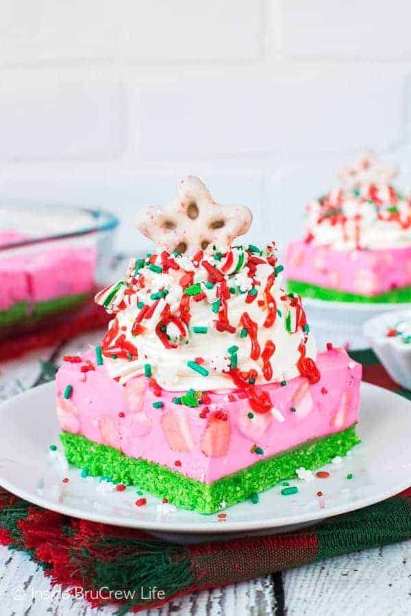 No Bake Peppermint Cheesecake Bars topped with a chocolate covered pretzel star on a white plate.