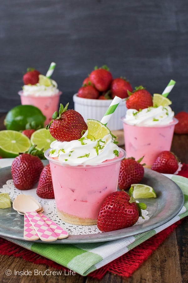 A metal plate with strawberries and a pink dessert on it.