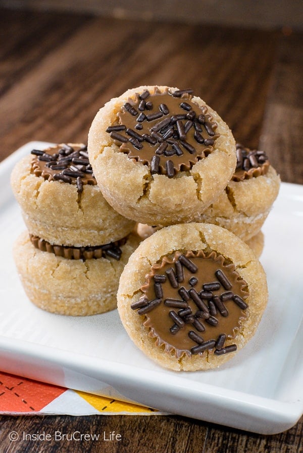 A white plate with peanut butter cup cookies stacked on it.