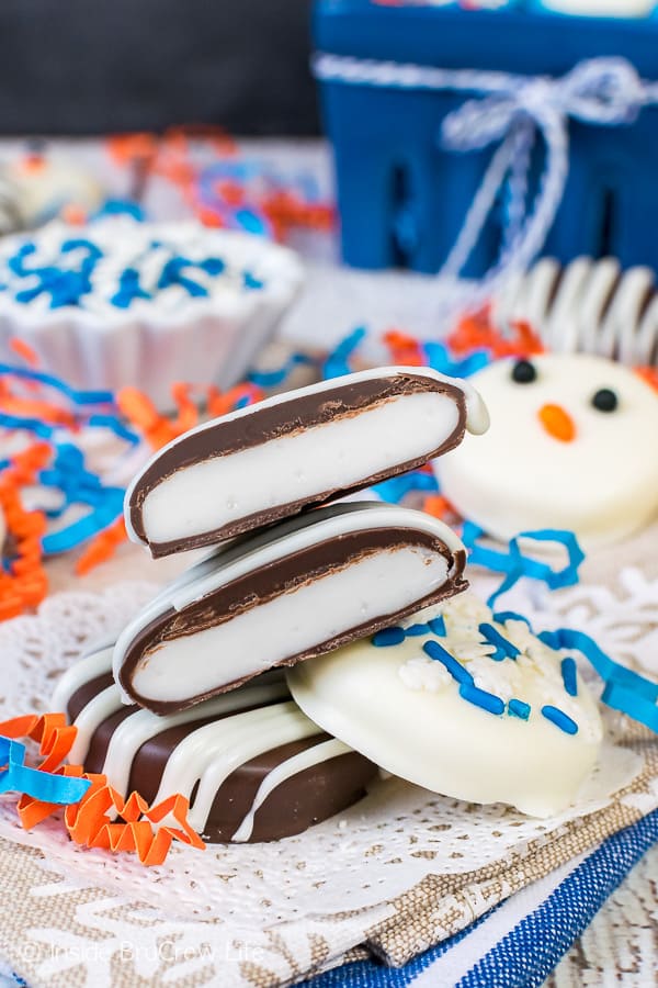 Three homemade peppermint patties stacked on top of each other on a white paper.