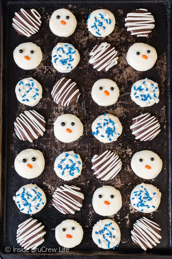 A metal tray with decorated peppermint patties lined up on it.