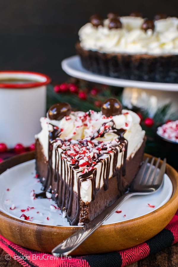 A slice of Peppermint Mocha Fudge Tart drizzled with chocolate and peppermint candy crumbles.