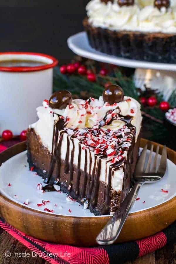 Peppermint Mocha Fudge Tart on a white plate with holly berries in the background.