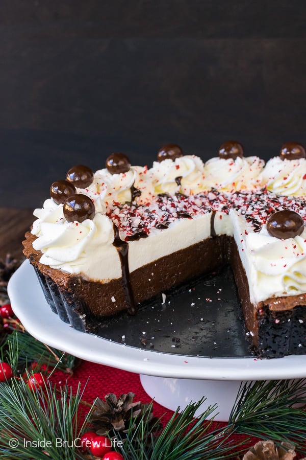 Peppermint Mocha Fudge Tart on a white cake plate with a slice taken out of the tart.