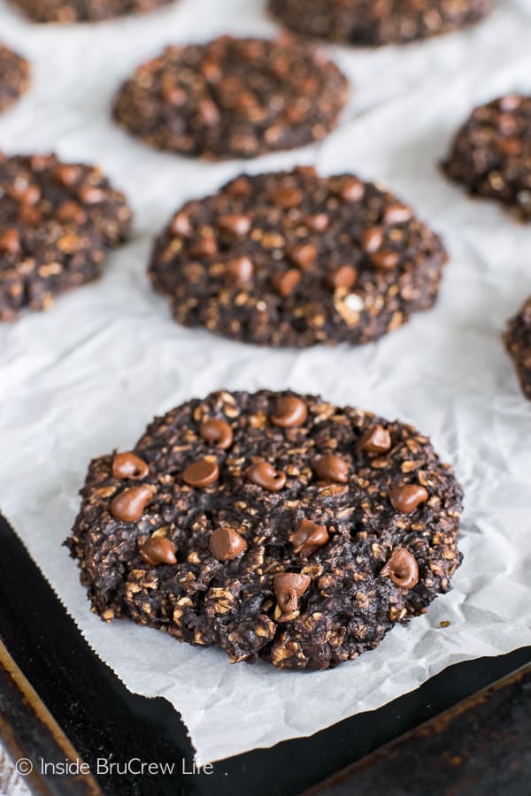 A tray with parchment paper on it and banana chocolate chip breakfast cookies on it