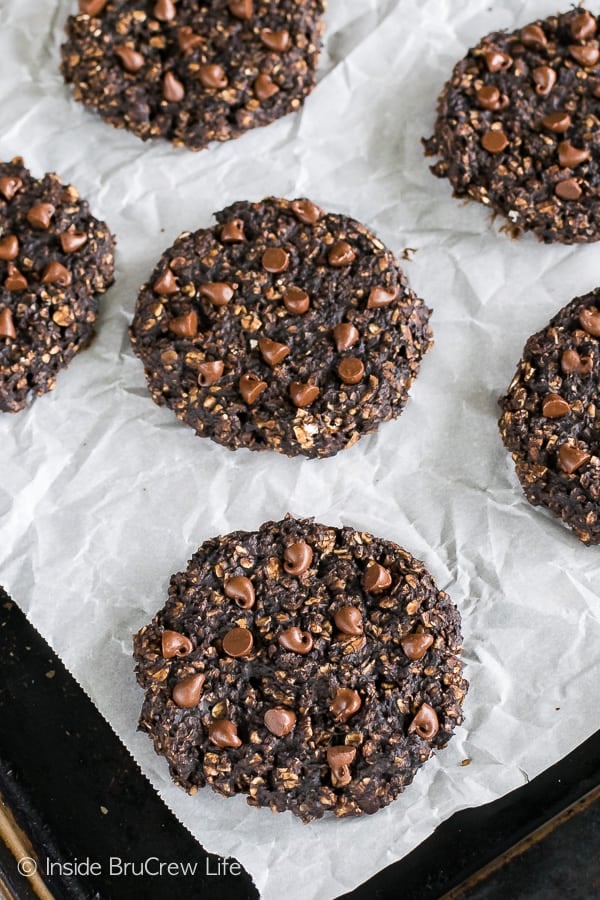 Overhead picture of banana breakfast cookies topped with mini chocolate chips on a tray with parchment paper