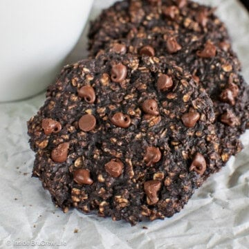 A couple of banana chocolate protein cookies on a lined pan.