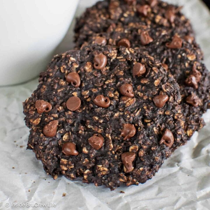 A couple of banana chocolate protein cookies on a lined pan.
